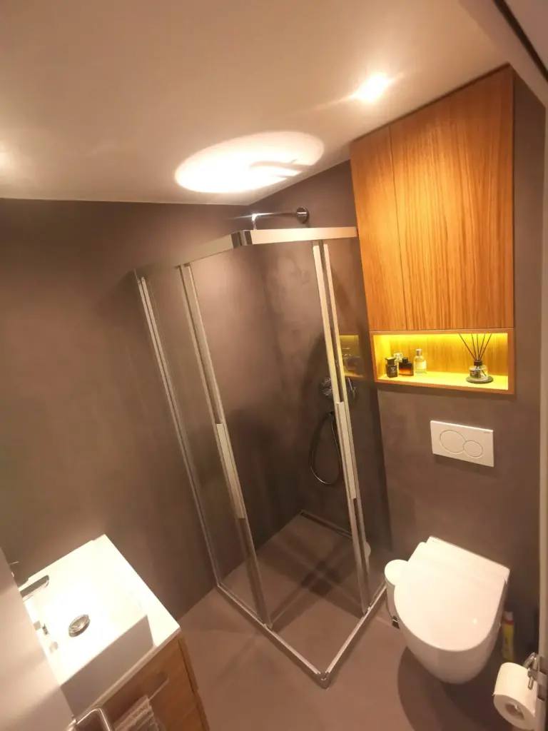 Neues Duschbad mit Eckdusche, Holzschrank und beleuchteter Nische