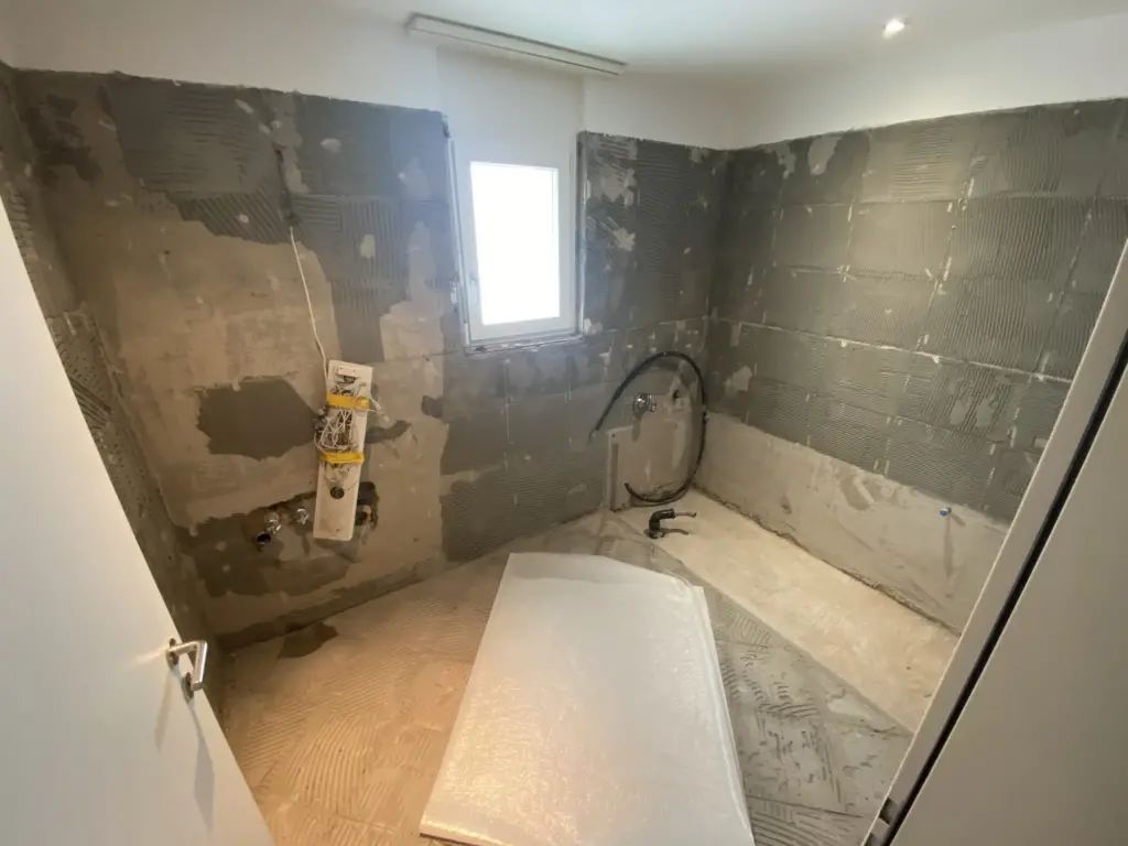 Badezimmer im Umbau mit freigelegten Wänden und neuer Badewanne