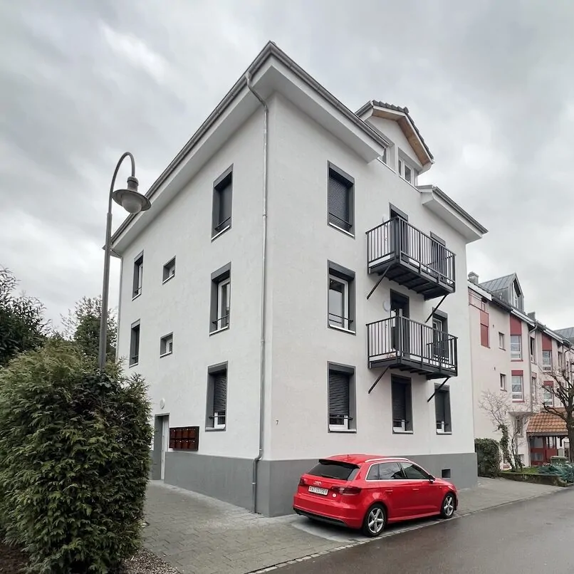 Strassenansicht des sanierten Mehrfamilienhauses mit Balkonen