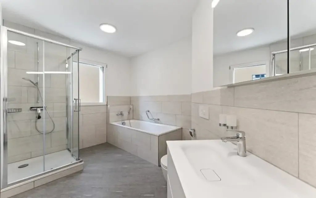 Badezimmer mit Eckdusche, Badewanne und Doppelwaschtisch