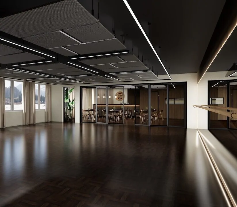 Saal mit dunklem Parkett, Lichtbändern an der Decke und Bar im Hintergrund