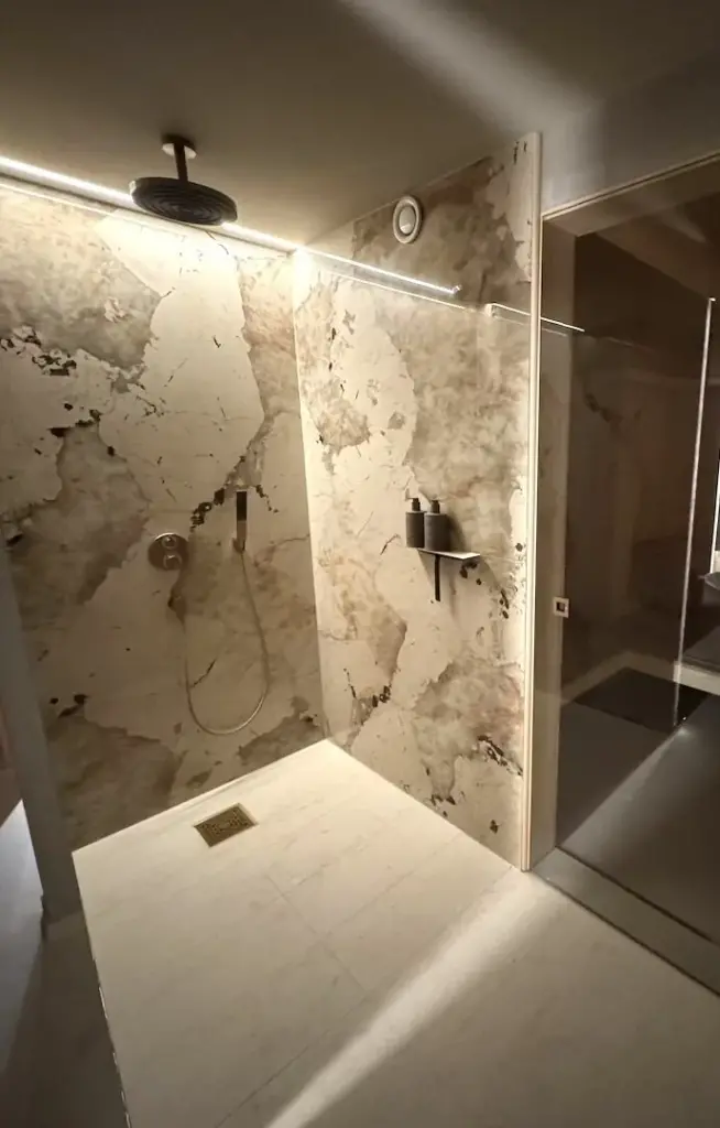 Begehbare Dusche mit grossformatigem Marmor und Glasabtrennung