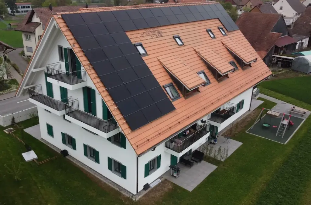 Mehrfamilienhaus mit Ziegeldach und Photovoltaikanlage aus der Luft