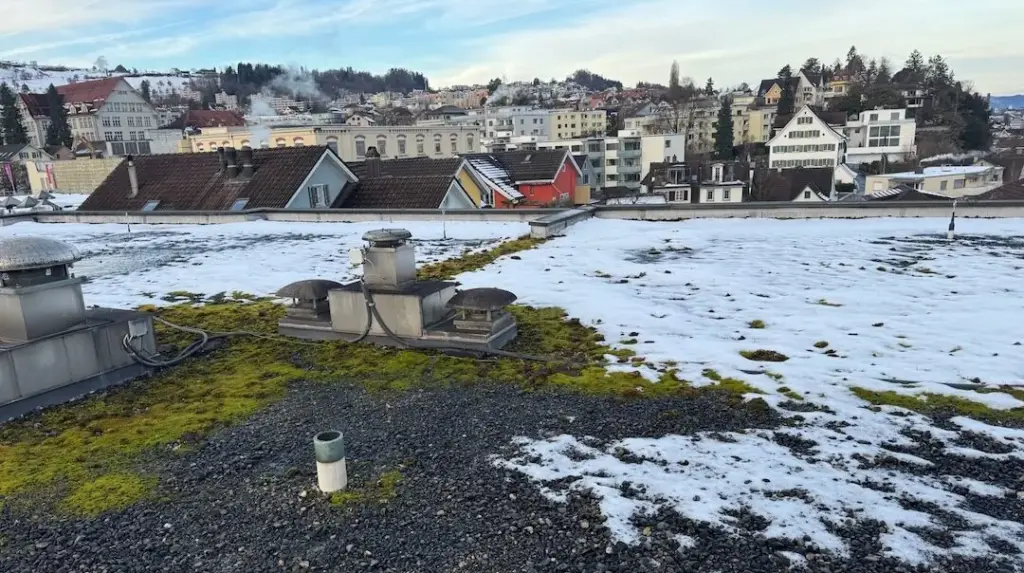 Bekiestes Flachdach mit Lüftungshauben und Blick über die Ortschaft