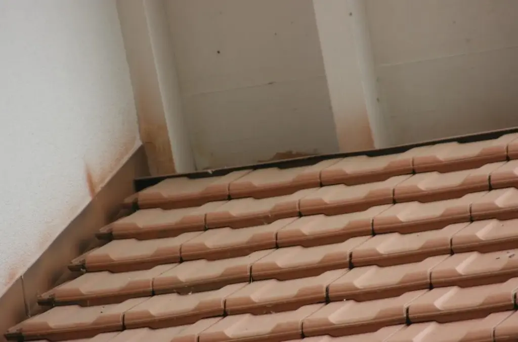 Detail der Ziegeleindeckung am Anschluss zur verputzten Wand