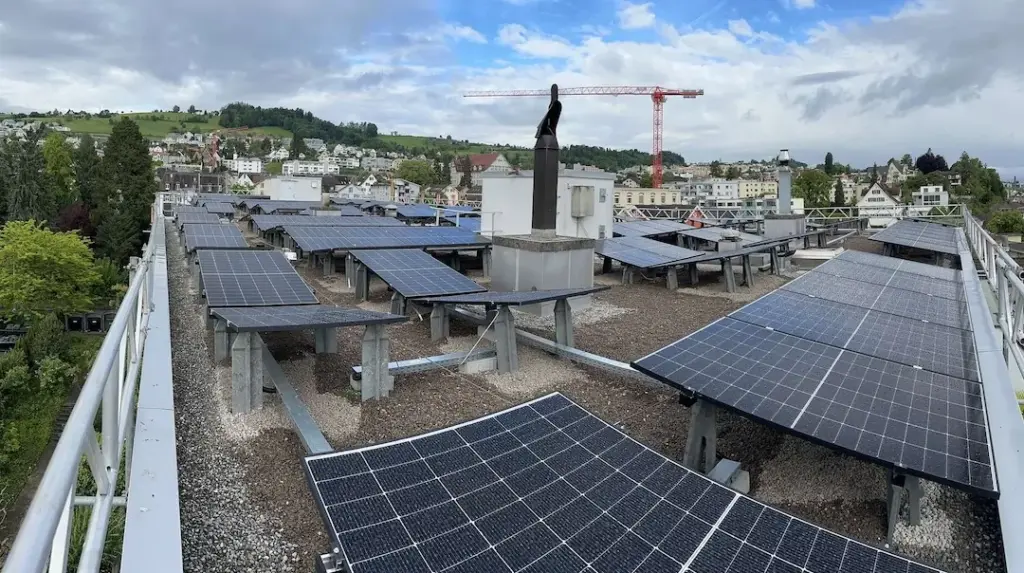 Flachdach mit aufgeständerter Photovoltaikanlage und Baukran im Hintergrund