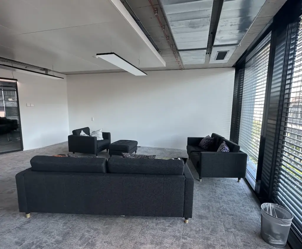 Sitzecke mit dunklen Sofas vor dem Umbau